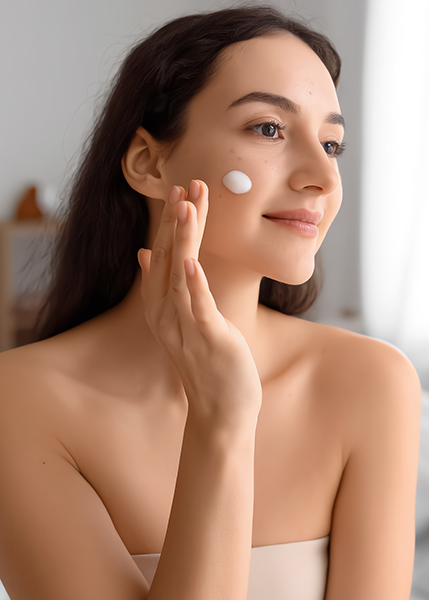 Woman gently applying acne gel to her cheek, demonstrating a lightweight, calming treatment for clear skin by ORY Skincare.