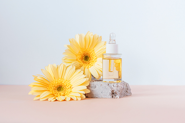 Calendula face oil with golden botanical extract displayed beside fresh calendula flowers, representing a nourishing ORY Skincare facial oil routine.