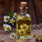 Bottle of chamomile infused oil on rustic fabric — soothing chamomile oil ingredient for ORY Skincare.