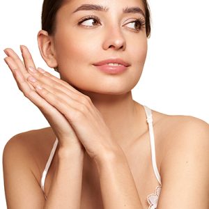Woman with smooth, hydrated complexion gently touching her face, representing ORY Skincare’s pre-formulated bi-phasic serum for dry skin designed to replenish moisture, restore comfort, and enhance skin radiance.