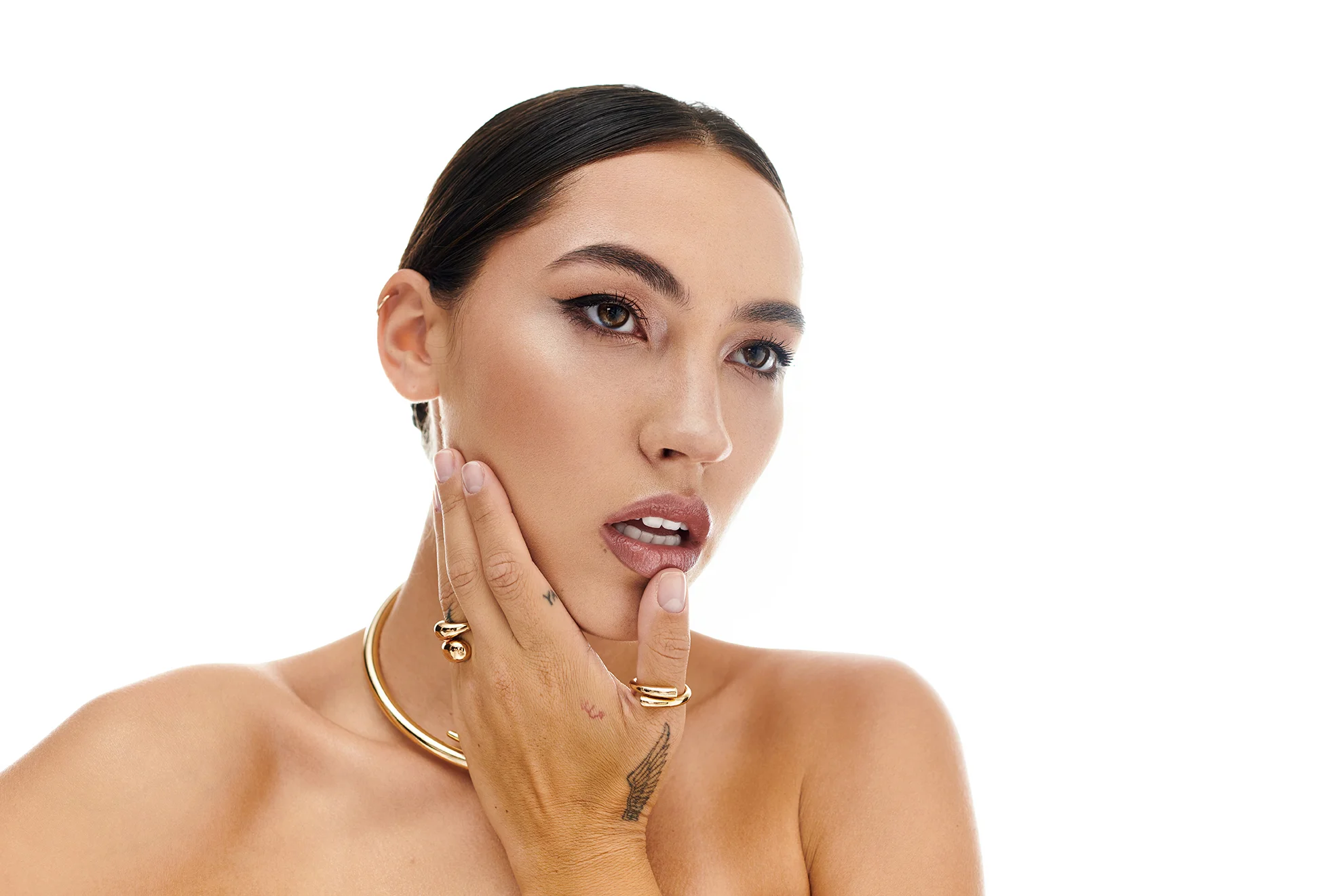 Woman with smooth, luminous dry skin touching her face, representing ORY Skincare solutions for dry skin hydration, nourishment, and barrier support.